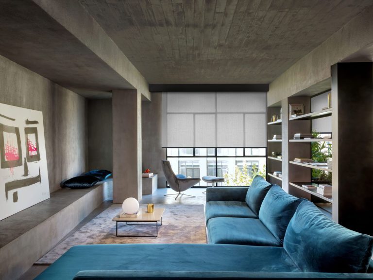 A living room setting with a large art work standing next to one wall. Grey coloured blinds are half way down the window.